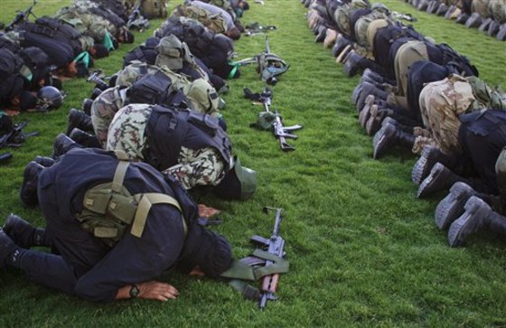 Hamas militants pray before going to pay their respects to freed Palestinian prisoners in Rafah, southern Gaza Strip, on Wednesday. Tens of thousands of flag-waving Palestinians celebrated the homecoming of hundreds of prisoners exchanged for an Israeli soldier on Tuesday.